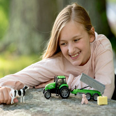Breyer Tractor and Tag A Long Wagon being played with by a young girl