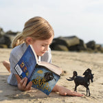 Breyer Freedom Series The Black Stallion Horse and Book Set being used by a young girl on the beach